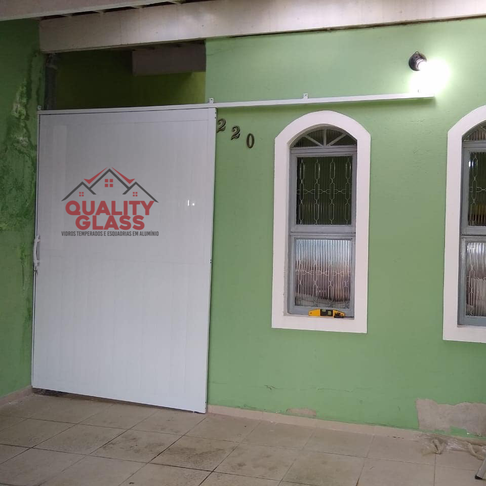 Porta de entrada branca instalada em fachada residencial
